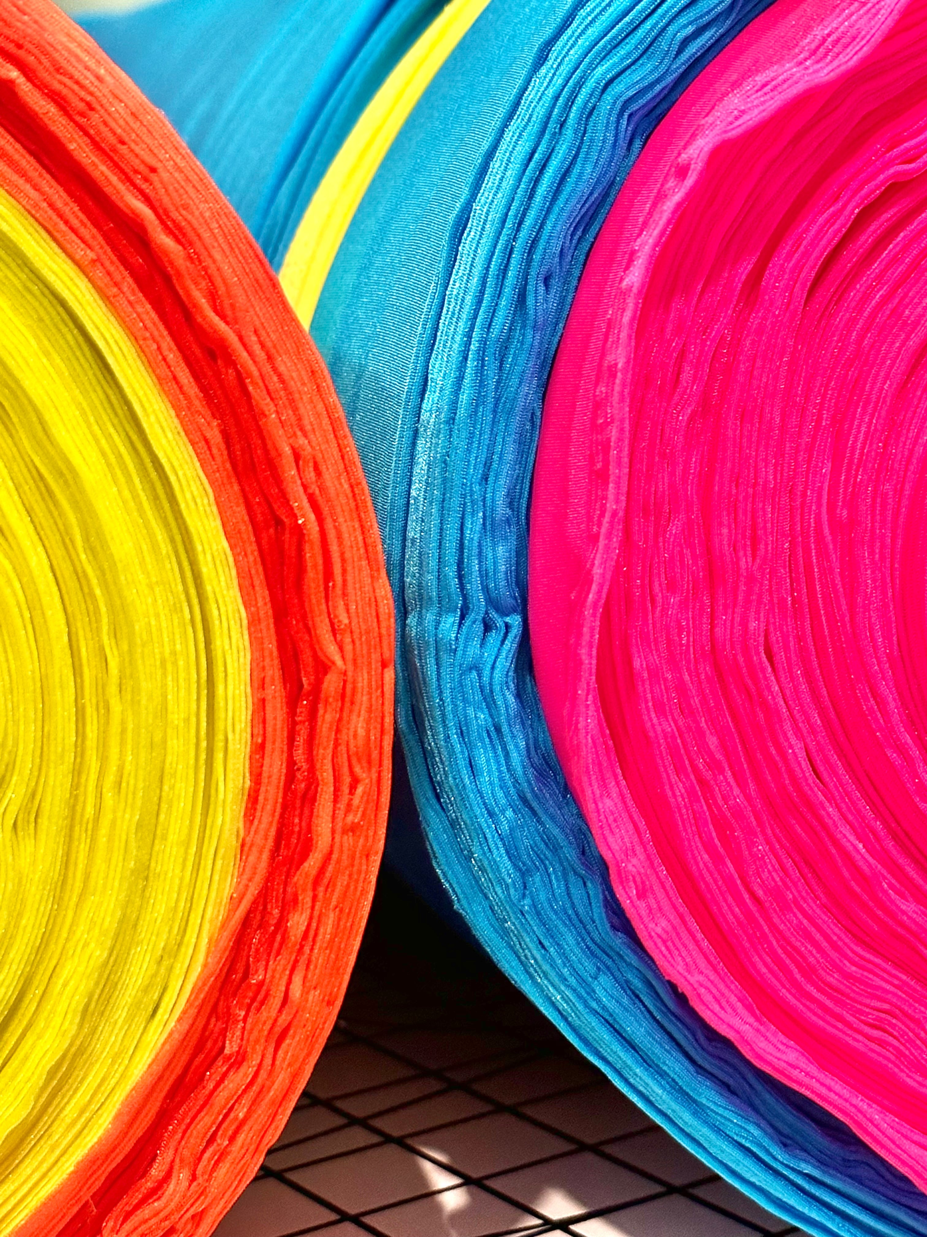 Neon swimwear fabric on rolls. HiViz neon swimwear for kids.