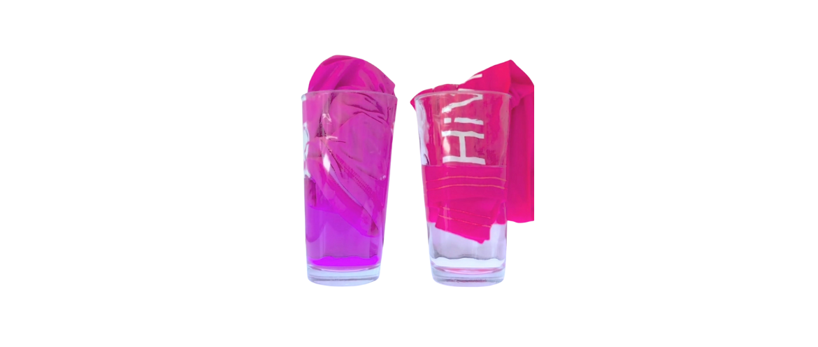 Two piececs of swimwear in glasses with water in them one has dyed the water pink.