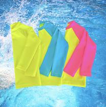 Three neon yellow neon pink rash guards laid out on a water background. Rash guards for kids.