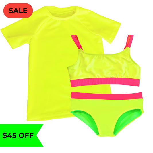 Bright neon yellow UPF short sleeved sun shirt rash guard  paired with a girls' swimsuit featuring neon yellow and neon pink accents, along with reversible bikini bottoms in neon yellow and neon green. This hi vis swimsuit is designed for high visibility, allowing the swimmer to stand out from any background."