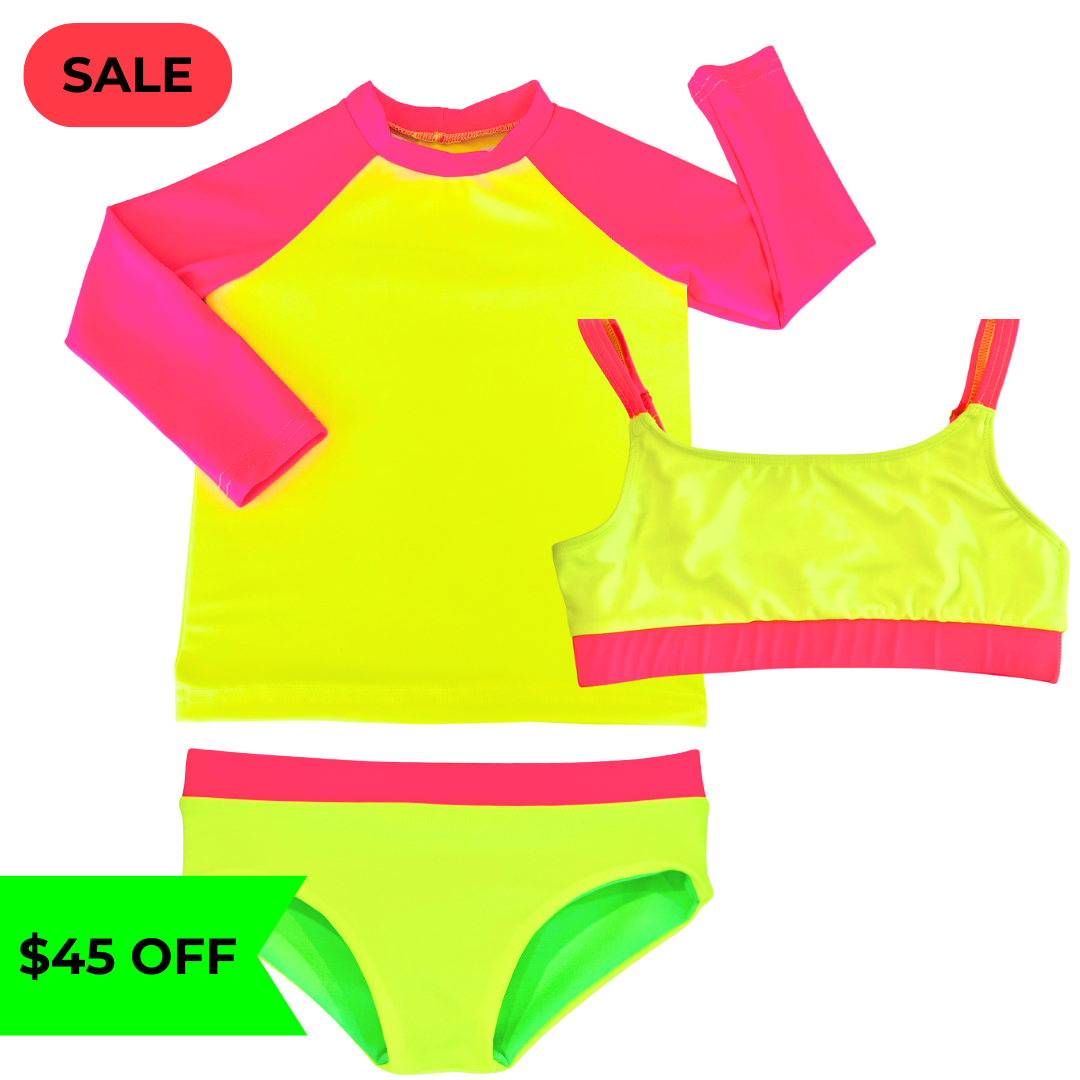 Bright neon yellow UPF long sleeved sun shirt rash guard  with neon pink sleeves paired with a girls' swimsuit featuring neon yellow and neon pink accents, along with reversible bikini bottoms in neon yellow and neon green. This hi vis swimsuit is designed for high visibility, allowing the swimmer to stand out from any background."