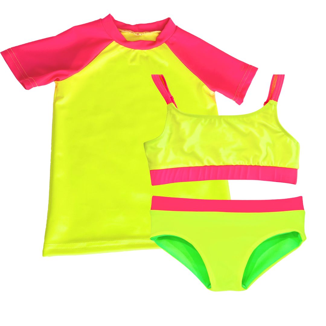 This girls swimsuit includes a bright neon yellow UPF sun shirt rash guard with neon pink short-sleeves paired with a neon bikini girls swimsuit featuring neon yellow and neon pink accents, along with reversible bikini bottoms in neon yellow and neon green. This bright swimsuit is designed for high visibility, allowing the swimmer to stand out from any background.