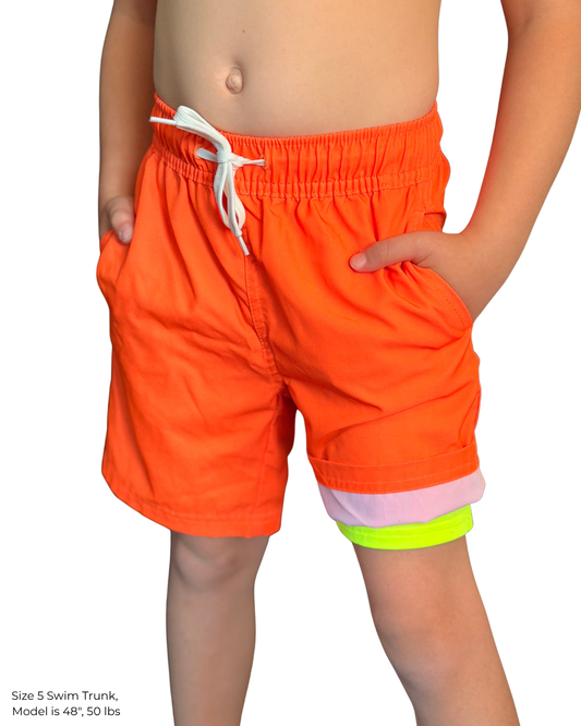 Child wearing hi-vis neon orange swim trunks with a white drawstring and neon yellow boxer-brief liner visible at the leg.