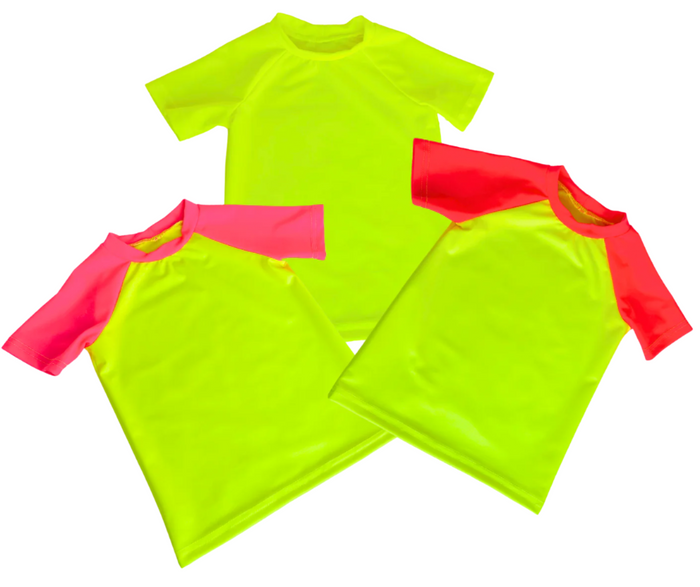 Product photo of three neon kids short sleeve swim shirts. From right to left, kids neon swim shirt neon pink and neon yellow short sleeve rash guard, then a solid neon yellow short sleeve rash guard, and then a neon red and neon yellow short sleeved rash guard. Putting your kids in bright swim shirts protects them from the sun and makes them stand out to easily spot them in and around water. 