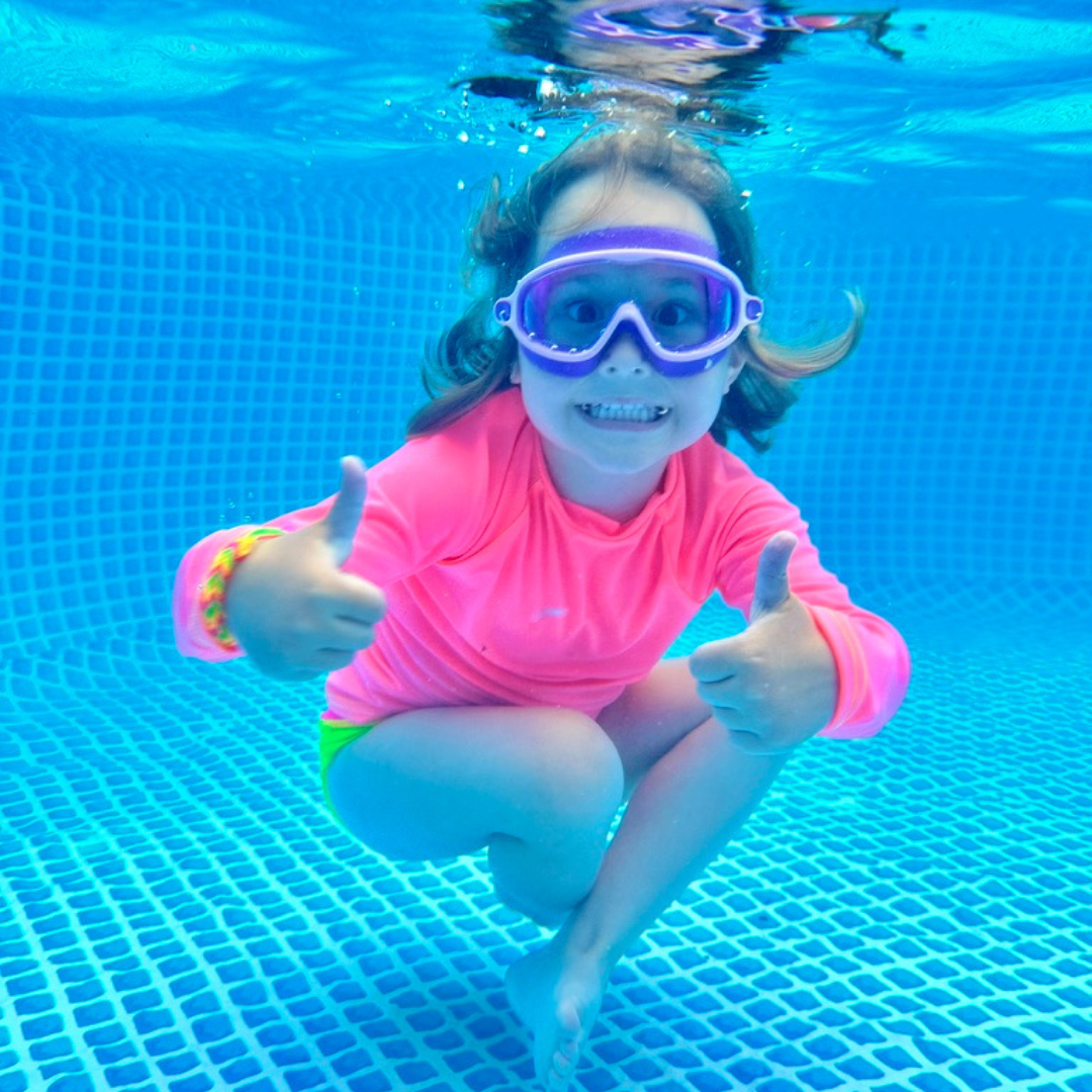 Kids neon swimwear, neon coral rash guard glowing under water.