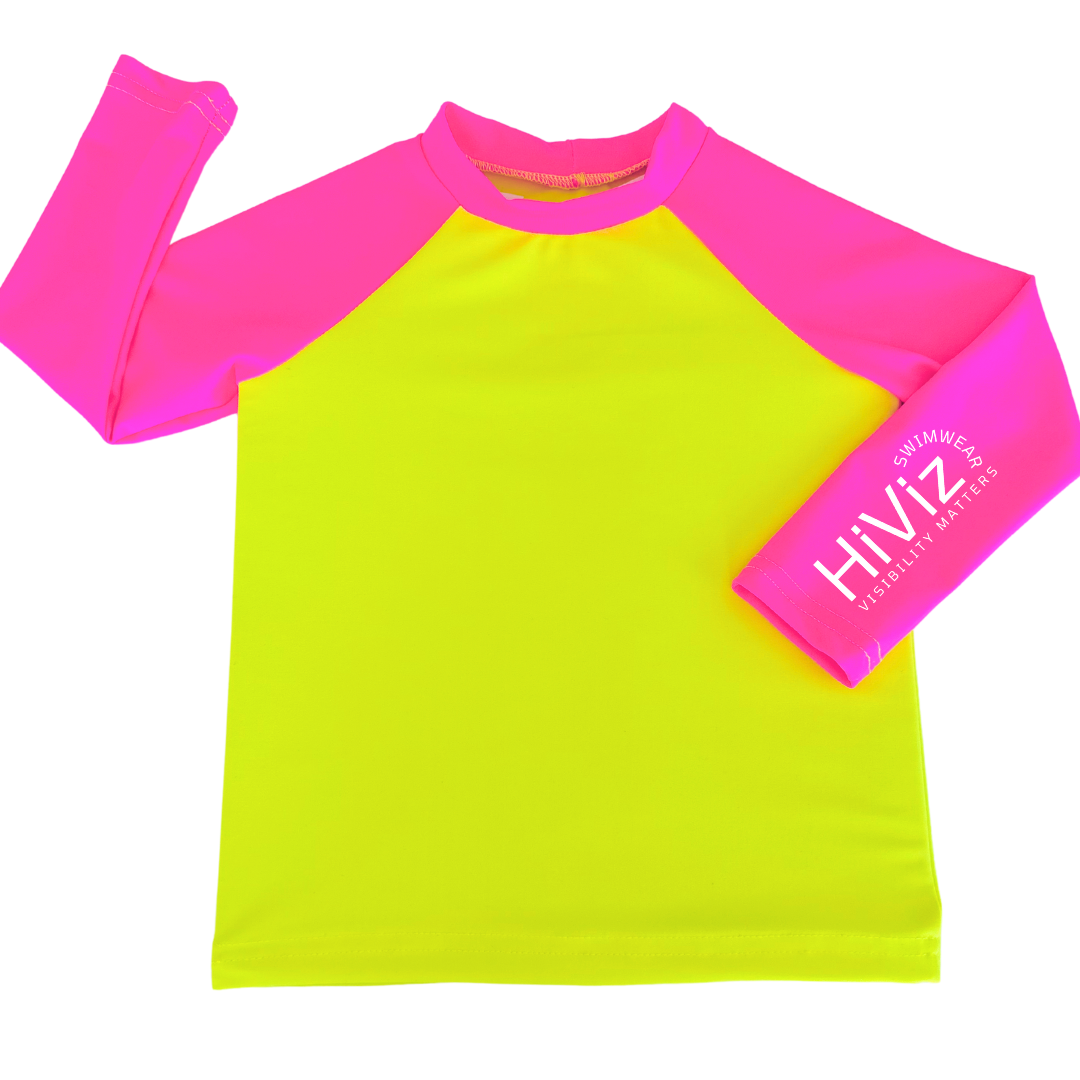 Bright swimwear for kids, this is a product image of a kids' neon yellow rash guard with neon pink sleeves with HiViz bright swimwear logo on the left sleeve.