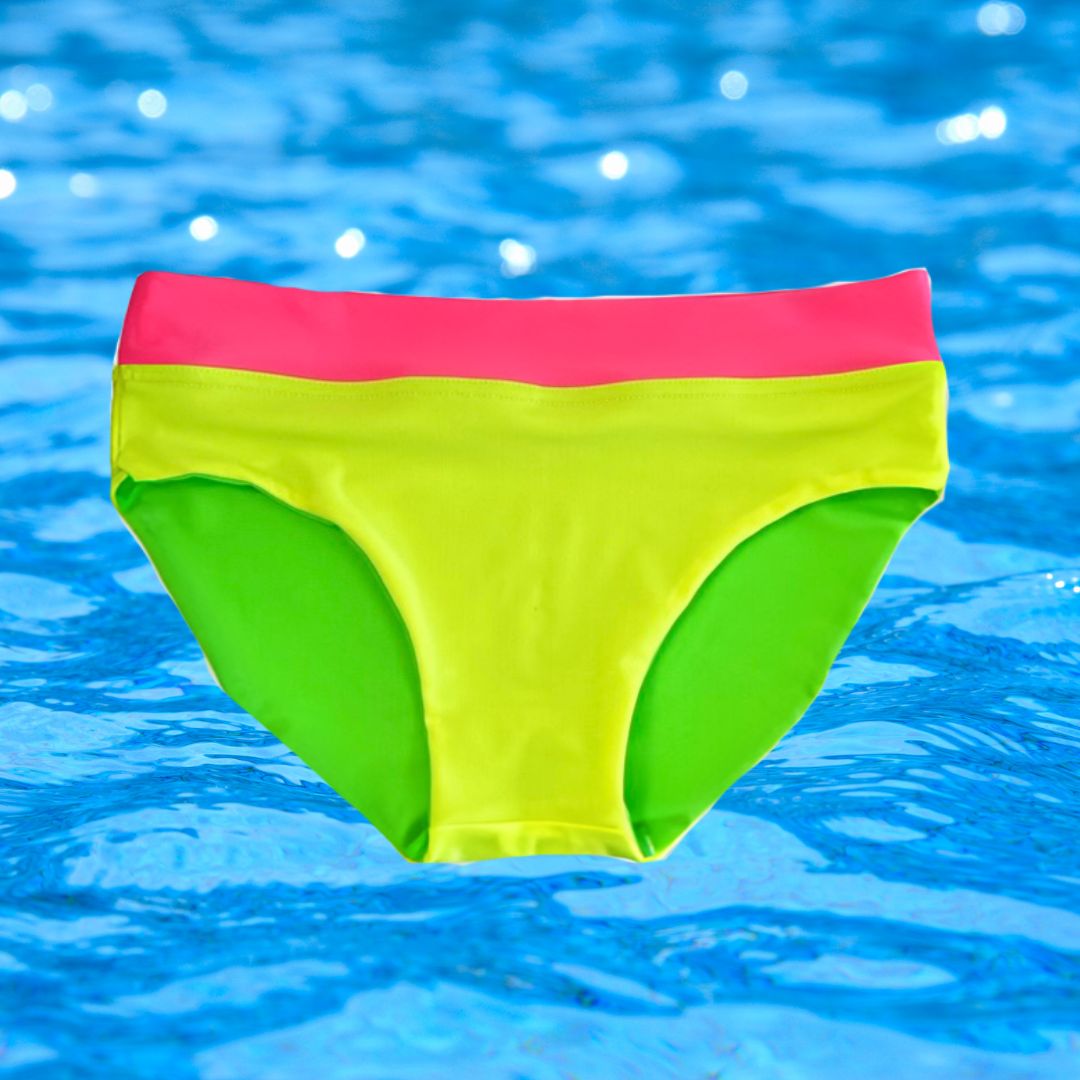 Product image of neon yellow bikini bottoms from HiViz swim's bright swimwear line. These bright swimsuit bottoms are on a backdrop of blue pool water. 