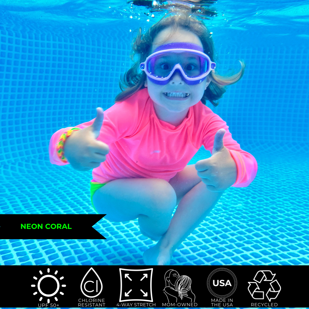Kids neon swimwear, neon coral rash guard glowing under water.