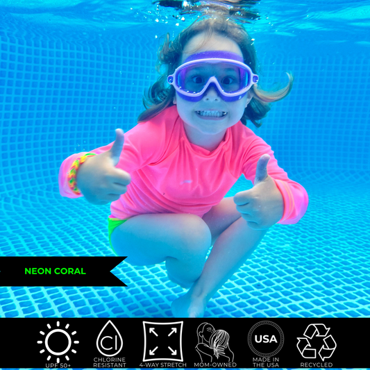 Kids neon swimwear, neon coral rash guard glowing under water.