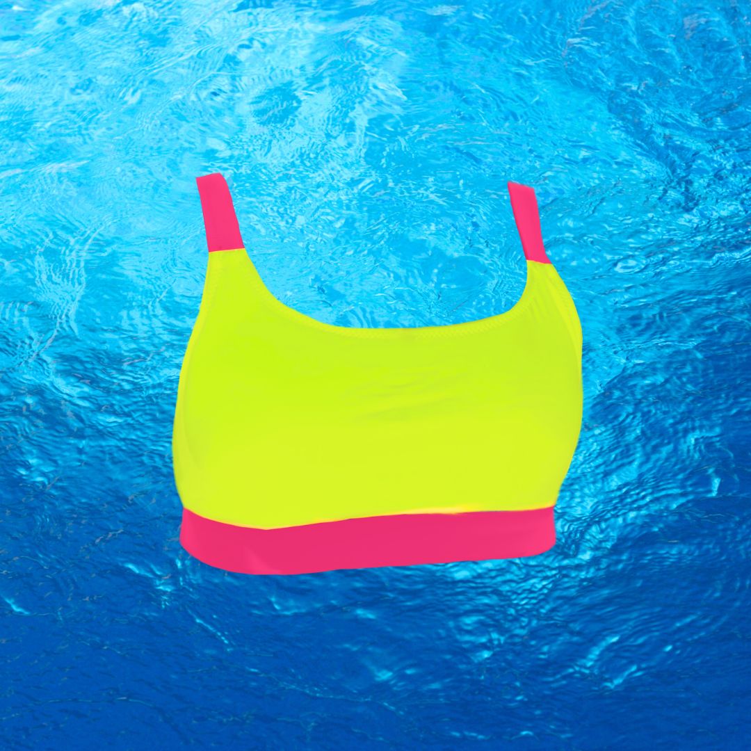 Neon bikini top that is neon yellow with neon pink straps and a neon pink band. Bright swimwear product image stands out against the blue water background. 